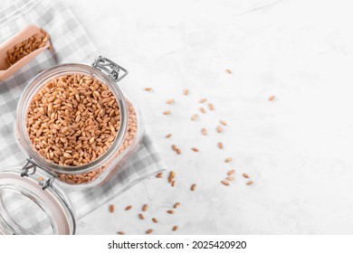 Wholegrain Uncooked Raw Spelt Farro In Glass Jar On Grey Stone Table Background, Food Cereal Background, Close Up, Kitchen Zero Waste, Copy Space