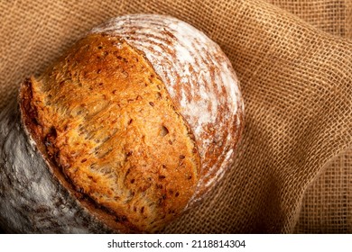 Wholemeal sourdough bread isolated on burlap cloth.