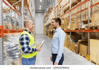 wholesale, logistic business and people concept - manual worker and businessman with clipboards at warehouse