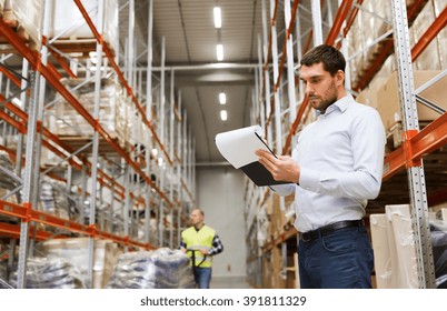 wholesale, logistic, people and export concept - businessman or supervisor with clipboards at warehouse