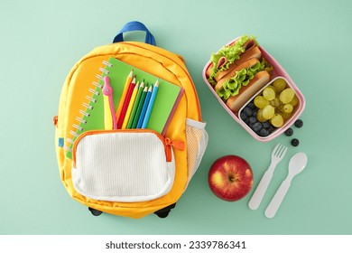 Wholesome snack idea for educational settings. Top view photo of lunchbox, apple, cutlery, compass, pencils, notebook, rucksack on turquoise background with empty space for advert or text - Powered by Shutterstock