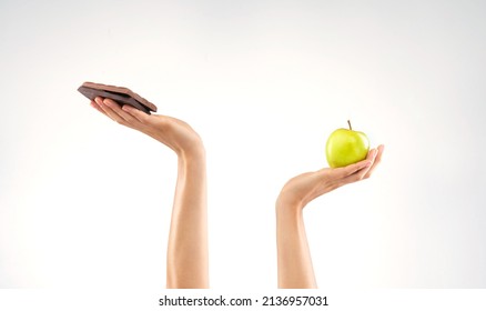 Why Cant I Choose Both. Studio Shot Of An Unrecognizable Woman Deciding Between Healthy And Unhealthy Foods Against A Grey Background.