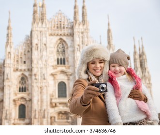 Why Not To Hang Out In Italian Fashion Capital Milan On Winter Holidays With Family. Smiling Mother And Daughter Looking On Photos In The Digital Camera In Front Of Duomo