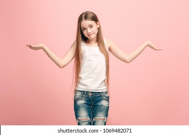 Why is that. Beautiful female half-length portrait on trendy pink studio backgroud. Young emotional surprised, frustrated and bewildered teen girl. Human emotions, facial expression concept.