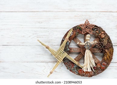 Wiccan altar for Imbolc sabbat. pagan festive ritual. wheel of the year, Brigid's cross from straw, amulet, witchcraft doll on white wooden table. Imbolc holiday, spring equinox. flat lay. copy space