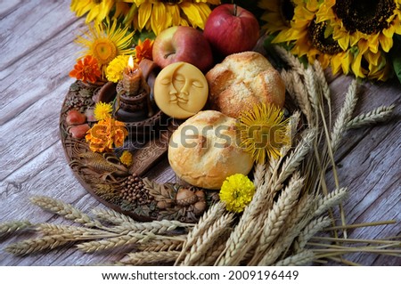 Wiccan Altar for Lammas, Lughnasadh pagan holiday. wheel of the year with ears of wheat, amulet, bread, flowers, apple, candle on dark wooden background. symbol of wiccan sabbat, harvest summer season