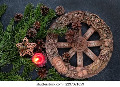 wiccan altar with Wheel of the year, candle, amulet deer, cones, fir branches on dark abstract background. Witchcraft Esoteric Ritual. symbol of Yule, Winter Solstice holiday. top view