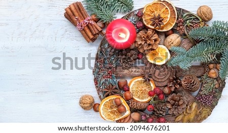 Wiccan altar for Yule holiday. Wheel of the year, candle, cinnamon sticks, nuts, cones, dry orange slices  on wooden table. Esoteric Ritual for Yule, Magical Winter Solstice, witchcraft. flat lay