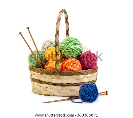 Wicker basket with balls of yarn isolated on white background