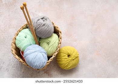 Wicker basket with colorful knitting yarn and needles on light grunge background - Powered by Shutterstock