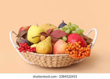 Wicker basket with different fresh fruits on beige background - Powered by Shutterstock