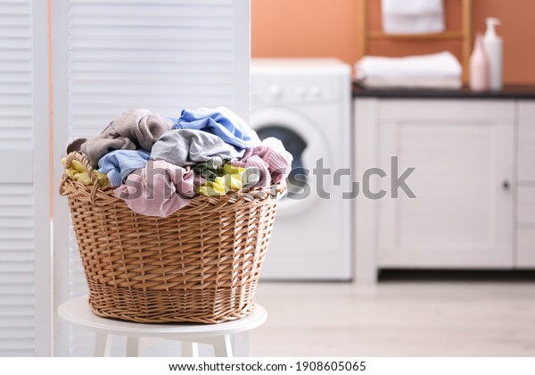 Wicker\
basket with dirty laundry indoors, space for\
text