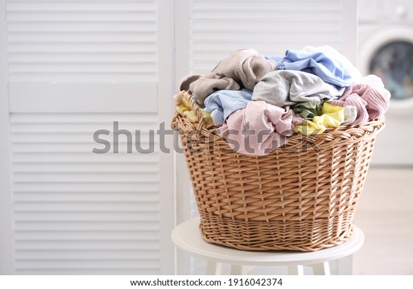 Wicker\
basket with dirty laundry indoors, space for\
text