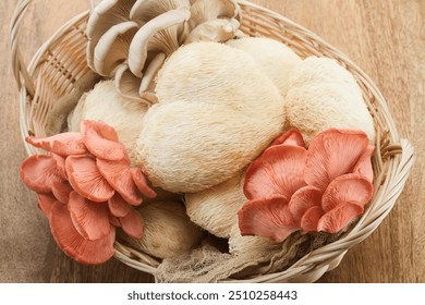 A wicker basket displaying various exotic mushrooms including lion's mane and pink oyster mushrooms. - Powered by Shutterstock