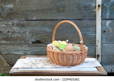 Wicker basket with Easter eggs on wooden table. 