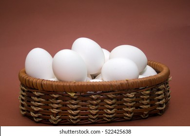wicker basket with eggs on a brown background