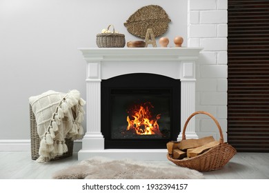 Wicker basket with firewood and white fireplace in cozy living room