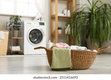 Wicker basket with laundry on floor in room - Powered by Shutterstock