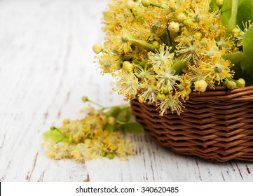 wicker basket with lime flowers on a old wooden background