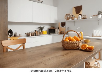 Wicker basket with oranges on table in kitchen