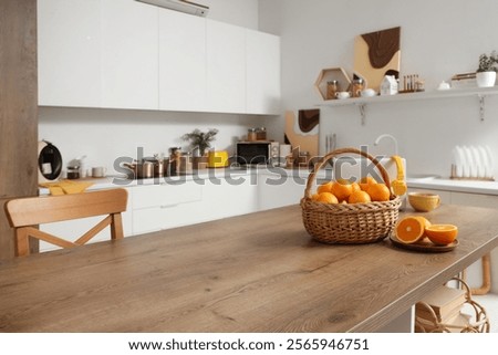 Wicker basket with oranges on table in kitchen