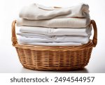 Wicker basket with a stack of white clothes on a white background. Clean, folded, stacked clothes in a wicker basket isolated.