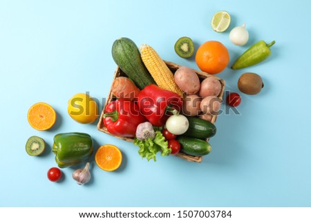 Wicker basket and vegetables on blue background, copy spaceWicker basket and vegetables on blue background, copy space