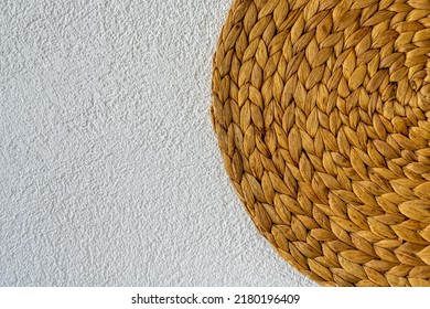 Wicker Basket Weave With Copy Space On White Grainy Background. Ecofriendly Round Natural Corn Straw On Spraying Lime Plaster White Wall.