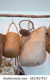 Wicker baskets hang beautifully arranged on a wooden rail.