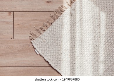 Wicker beige rug on wooden parquet floor with sunlit, top view - Shutterstock ID 1949967880