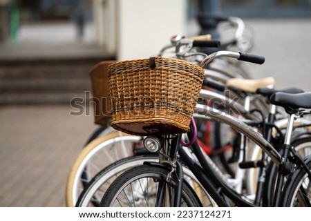 Wicker bicycle baskets close-up. A row of rental bicycles parked on a city street.