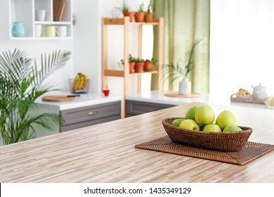 Wicker Bowl With Apples On Table In Modern Kitchen