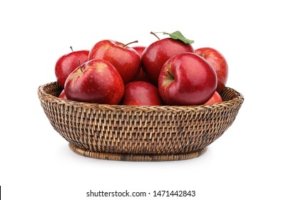Wicker bowl of ripe juicy red apples with leaf on white background