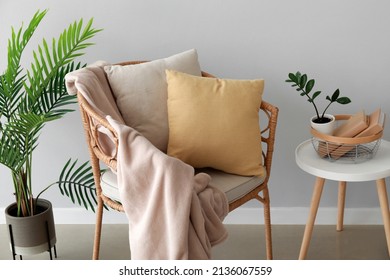 Wicker Chair With Pillow, Plaid And Table Near Light Wall