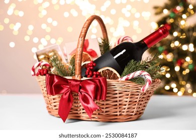 Wicker gift basket with wine and Christmas decor on light table - Powered by Shutterstock