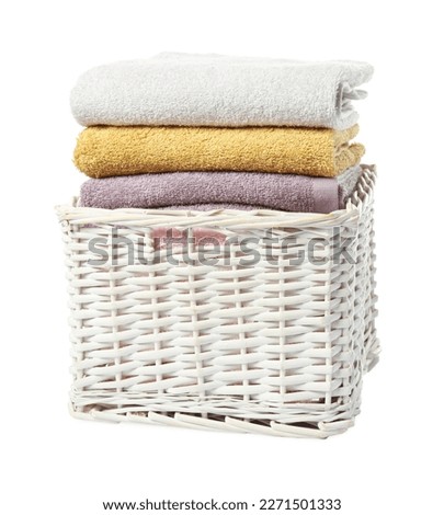 Wicker laundry basket with folded towels isolated on white