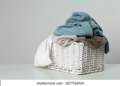 Wicker Laundry Basket With Towels On Light Background. Space For Text