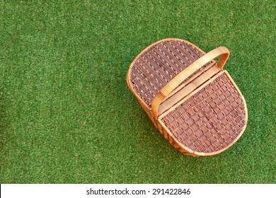 Wicker Picnic Basket On The Fresh Summer Grass Overhead View. Weekend Resting Concept