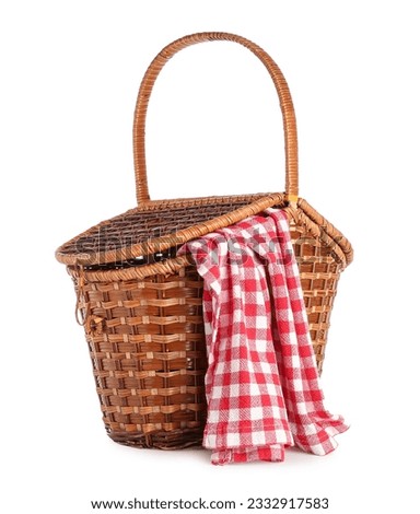 Wicker picnic basket with red checkered napkin on white background