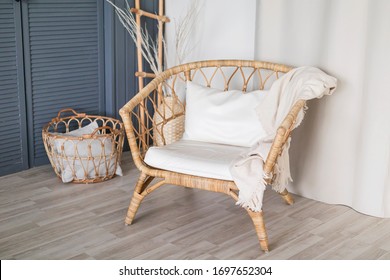 Wicker Wooden Chair With White Pillows And A Blanket