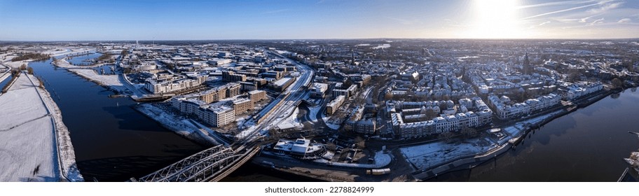 Wide 180 degree panorama ready for VR and steel draw bridge over river IJssel   white floodplains Dutch Hanseatic medieval tower town Zutphen  The Netherlands  Aerial cityscape after snowstorm
