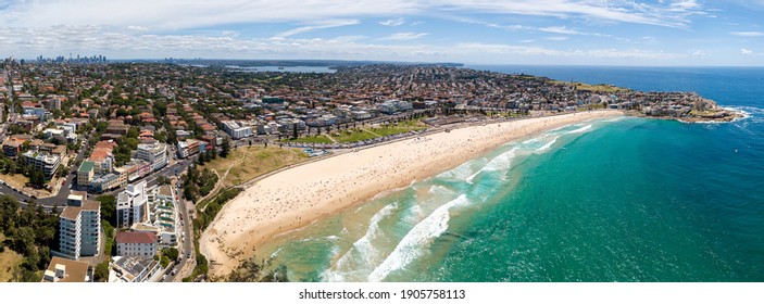 Wide Aerial Panorama Of Sydney Eastern Suburbs Facing Open Sea Of Pacific Ocean With Vista Of Famous Bondi Beach. City CBD Towers On Horizon.