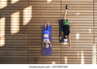 wide aerial view of a senior couple practicing yoga on wooden floor - Powered by Shutterstock