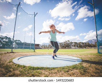 Wide angle action photo of a female discus athlete throwing a discus - Powered by Shutterstock