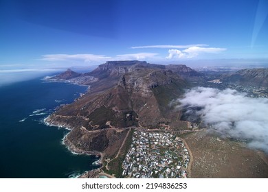 Wide Angle Aerial View Of Coast Line From Hout Bay To Cape Town With Rocks Twelve Apostles, Table Mountain And Lions Head, Blue Sea, Blue Sky Few White Clouds