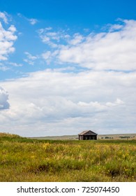 Wide angle clouds over green meadow with hoses under blue sky