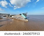 Wide angle drone shot showing The Deep building in Hull. Also showing the tidal barrier and Humber estuary.