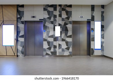 Wide Angle Front View Of Modern Lift Lobby, With Blank Advertising Media Spaces For Mockup Purpose. For OOH Concept In Office Or Retail Environment