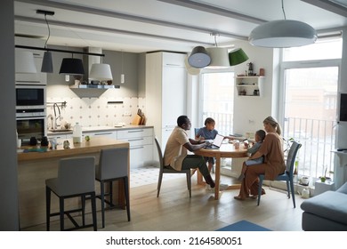 Wide Angle Home Scene Of Modern Multiethnic Family At Dinner Table In Kitchen, Copy Space