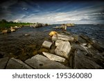 A wide angle image of the rough waters along the coast of the historic St. Lawrence Seaway. Taken from the Ontario, Canada side, New York state, USA is visible on the right, in the distance.